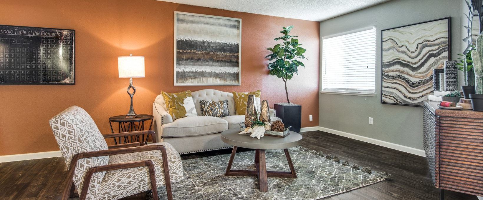 a living room with orange walls and wood floors at The  Mark at 2600