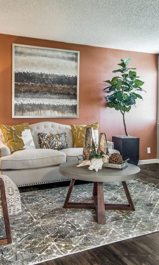 a living room with orange walls and wood floors at The  Mark at 2600