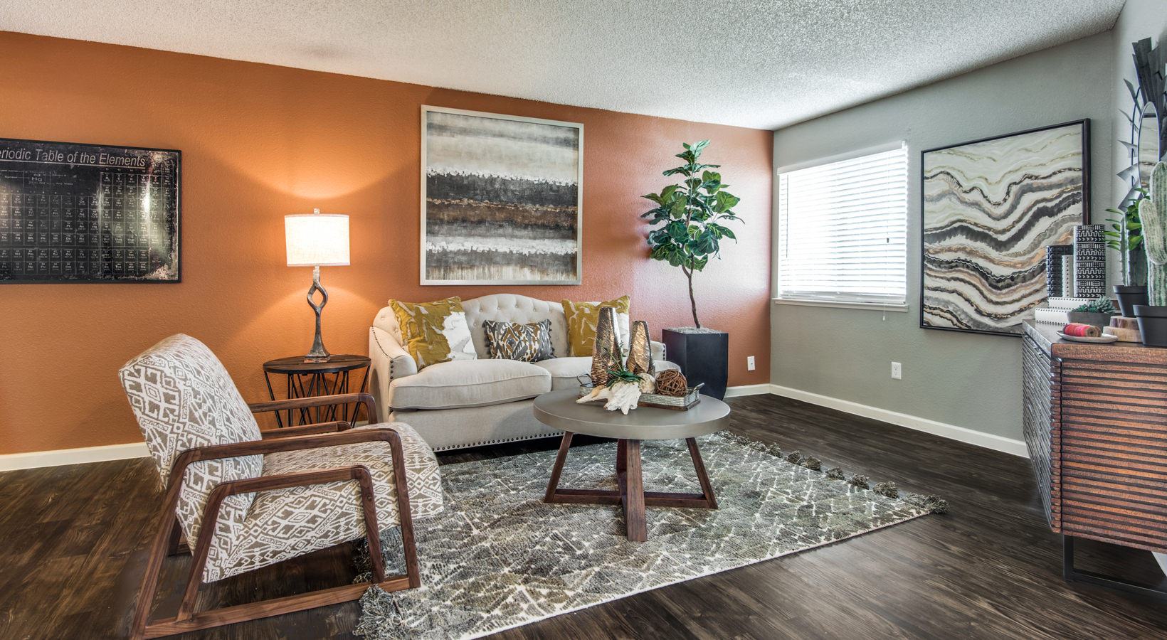 a living room with orange walls and wood floors at The  Mark at 2600