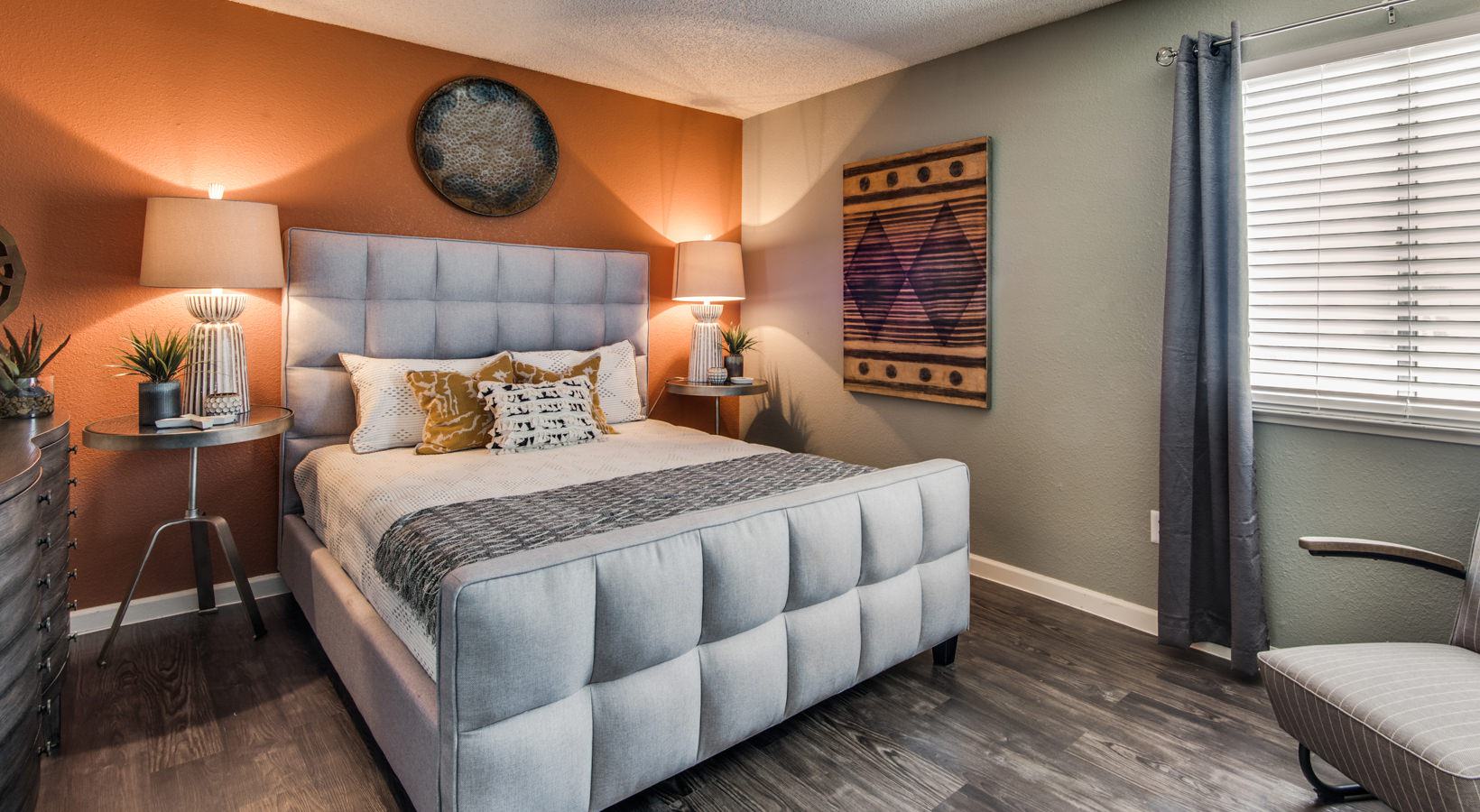 a bedroom with orange walls and a white bed at The Mark at 2600