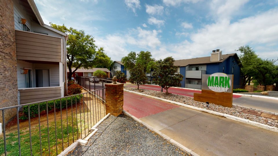 the entrance to a residential area with a green fence at The  Mark at 2600